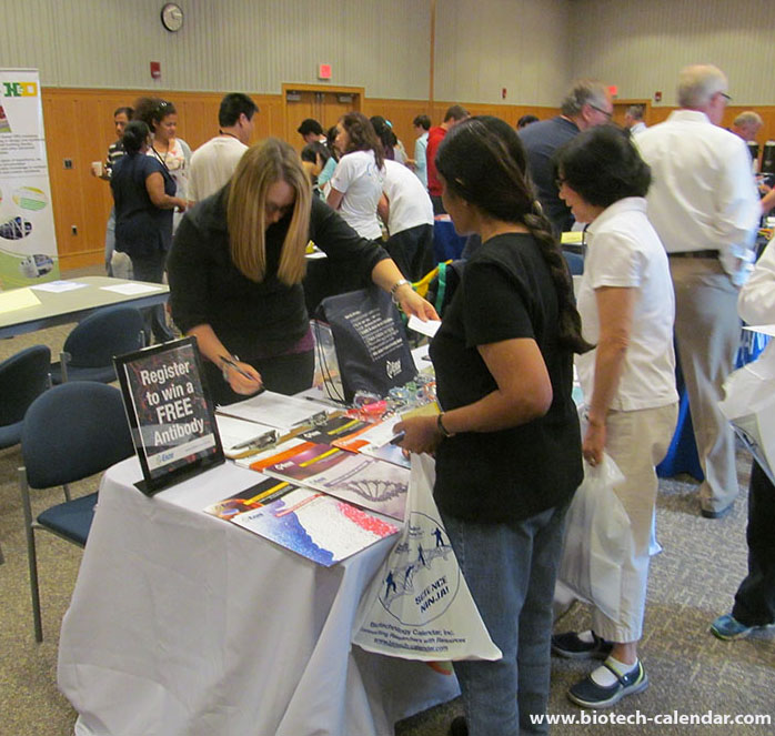 Researchers exchange contact information with a vendor at a BioResearch Product Faire™ at Ann Arbor