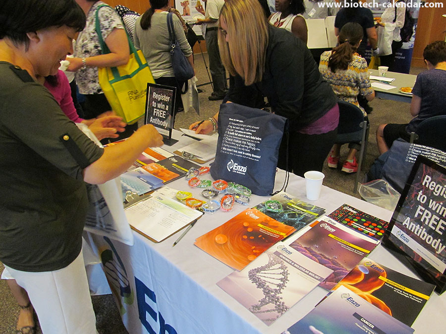Life science vendors shows off information atop a full table at the BioResearch Product Faire™ event in Ann Arbor